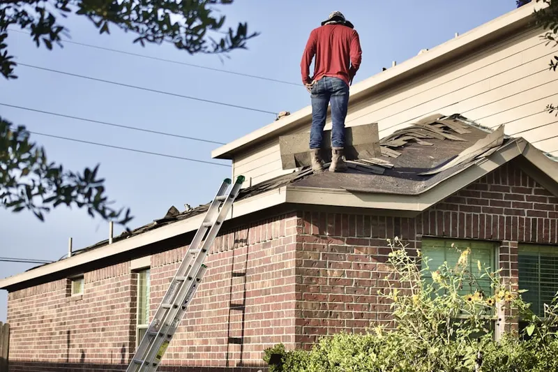 Professional roofer working on a residential roof in Justice